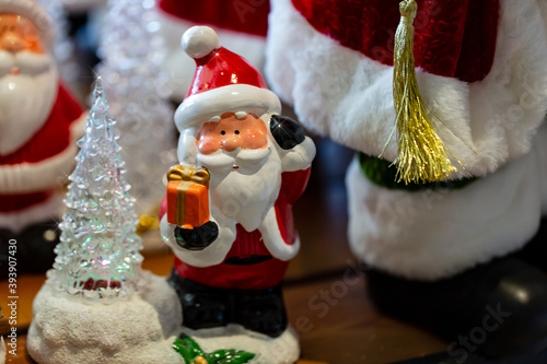 Santa Claus and Christmas tree flashes toy on blurred background. Merry Christmas and Happy new Year. Cute Santa Claus toy close up, copy space for text. Traditional santa claus