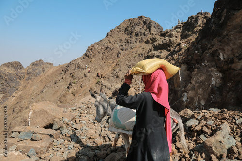 Women bring their food and drink needs through rugged mountain roads because  in the  west of Taiz City