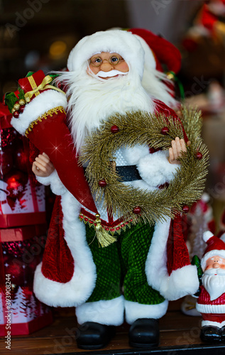 Santa Claus and Christmas tree toy on blurred background. Merry Christmas and Happy new Year. Cute Santa Claus toy close up, copy space for text, home decor.