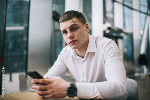 Pensive man browsing smartphone in cafe