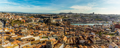 A wide-angle view towards the cathedral and the Douro river across the rooftops of Porto, Portugal from the Clerigos Tower on a sunny afternoon