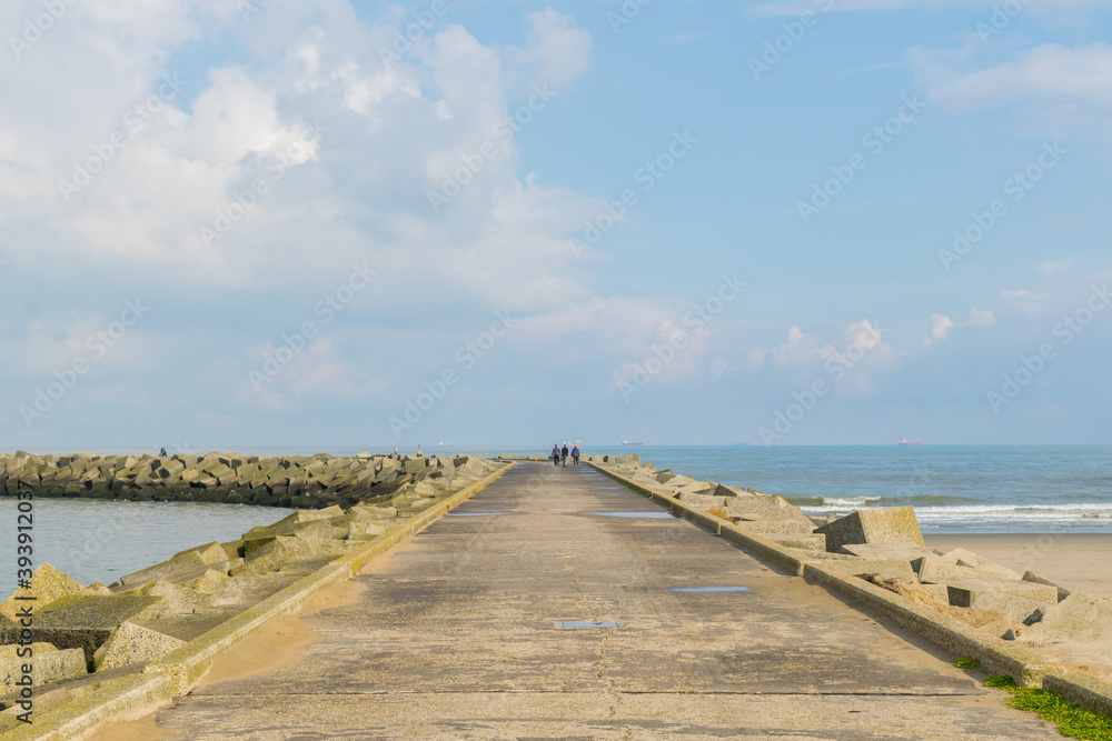 Panoramic view of a curvy footpath going towards a lighthouse at Scheveningen Beach located in The Hague, Netherlands