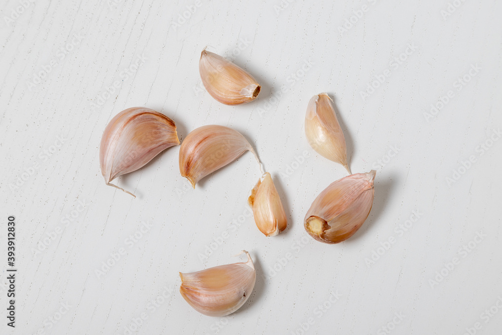 Peeled garlic cloves on a white table.