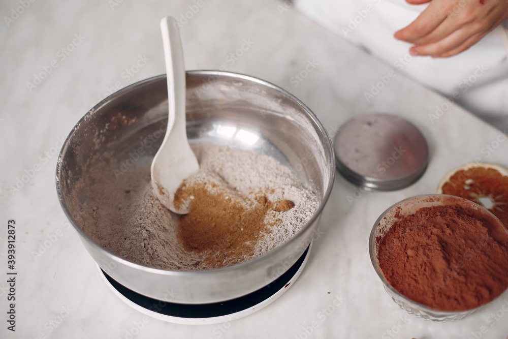 Woman poured cocoa into a bowl. Confectioner mixes the ingredients. Lady is preparing dessert. Woman poured cocoa into a bowl. Confectioner mixes the ingredients. Lady is preparing dessert.