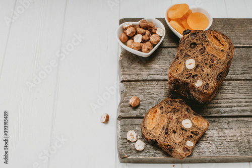 bread with dried fruits, nuts, dried apricots on a wooden Board on top copyspace