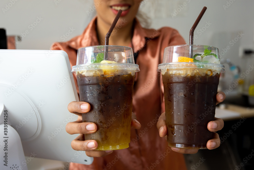 The employee handed over a coffee cup, orange coffee menu, to the customer at the counter The employee handed over a coffee cup, orange coffee menu, to the customer at the counter