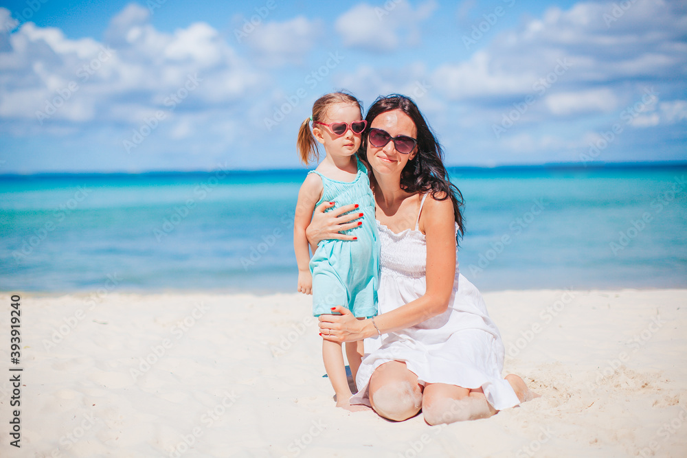 Beautiful mother and daughter at the beach enjoying summer vacation Beautiful mother and daughter at the beach enjoying summer vacation