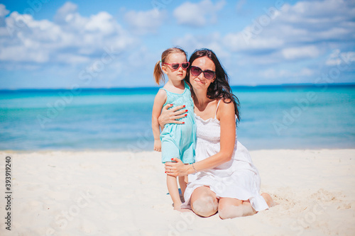 Beautiful mother and daughter at the beach enjoying summer vacation