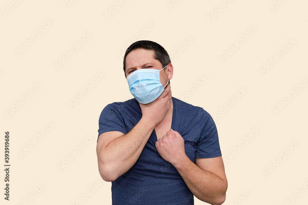 Adult White Man in surgical mask worried, stressed and he holding his neck with hand. Isolated on Set Sail Champagne color. Psychical health day. People negative emotions. Tired of Covid-19 pandemic Adult White Man in surgical mask worried, stressed and he holding his neck with hand. Isolated on Set Sail Champagne color. Psychical health day. People negative emotions. Tired of Covid-19 pandemic