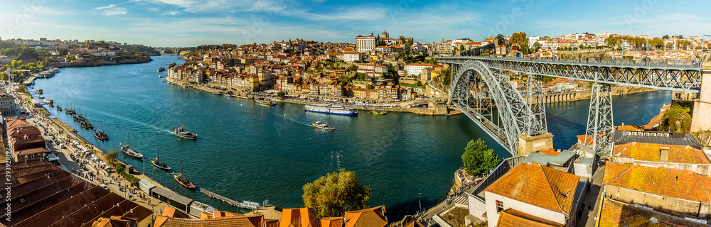 A panorama of the Douro river, the Dom Luiz bridge and the old quarter of Porto, Portugal on a sunny afternoon