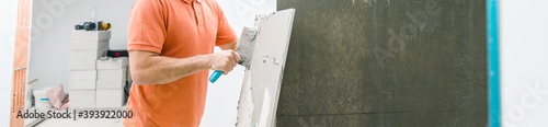Tiler installing large format tile on wall. home indoors renovation © karepa