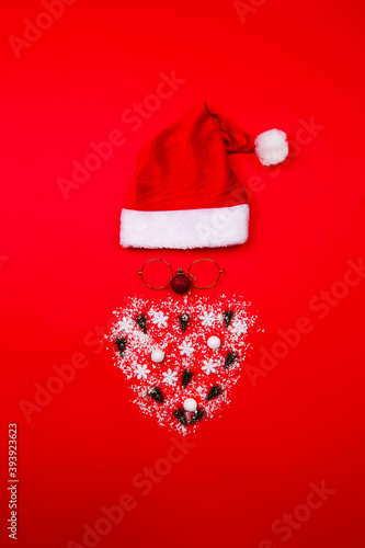 Santa Claus portrait with gold glasses on red background. Minimal flat lay Christmas theme. New year sale concept. photo