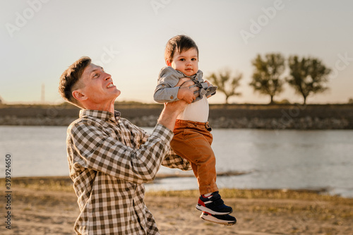 Portrait of loving father and his one years old son walking and playing outdoors