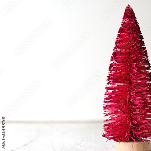 Pink bottle brush Christmas tree with copy space on white background, modern bright holiday. photo