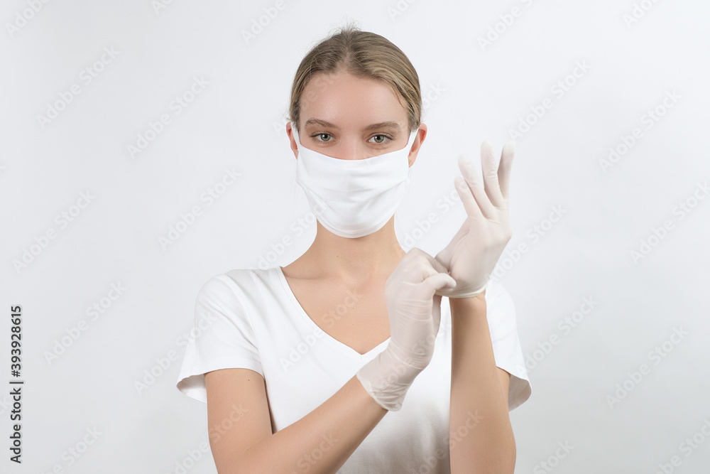 White young woman in face protection mask showing in front of her hands in medical disposable rubber gloves. White young woman in face protection mask showing in front of her hands in medical disposable rubber gloves.