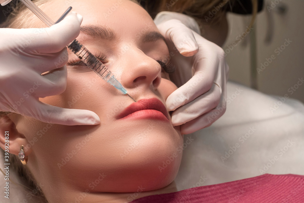 Woman getting cosmetic injection of botulinum to lips. Lip augmentation procedure in a beauty salon. Woman getting cosmetic injection of botulinum to lips. Lip augmentation procedure in a beauty salon.