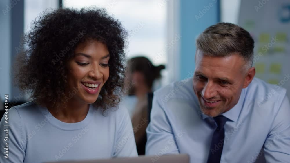 Smiling businesswoman and businessman looking at good work results in office Smiling businesswoman and businessman looking at good work results in office