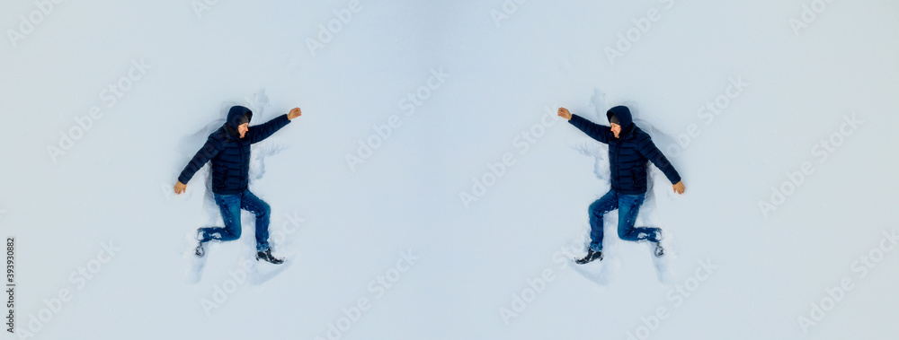 Boy makes a figure laying on a clean snow. View from above on a child in snow. winter fun concept.