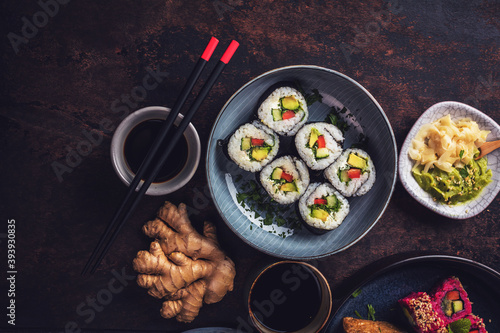 Delicious rolls, sushi and maki on a dark wooden Board with chopsticks. On black rustic background