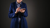 Young businesswoman in blue suit using phone. Cropped photo, isolated over grey background. Business support concept 