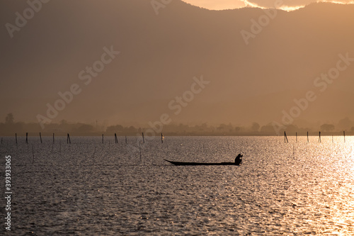 A Silhouette Fisherman row boat in Phayao Lake. Scenery sunset in Phayao Province , Thailand. © kitti