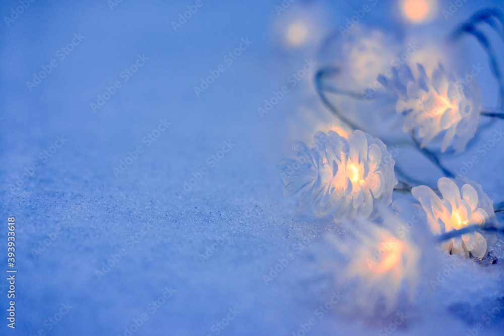 Φωτογραφία Christmas garland in the form of cones on the snow in the evening