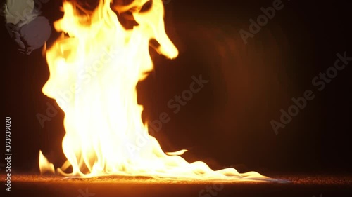 Slow motion footage of a burning match fall in a gasoline puddle. Beautiful fire wings with gasoline flame effects 