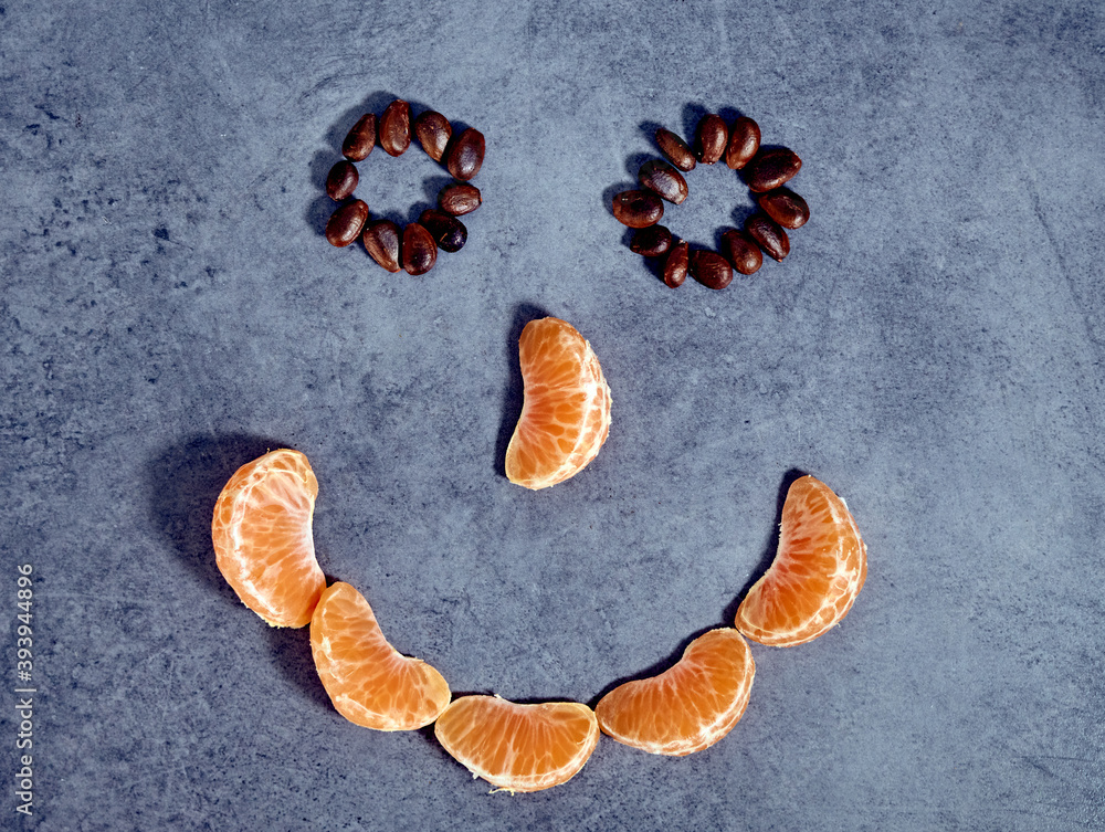 High angle shot of tangerine pieces and seeds shaped like a smiley face