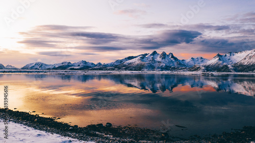 Breathtaking bird's eye view of high mountain rocky peaks covered with white snow reflected in Norway sea water. Breathtaking panoramic fjords landscape of Lofoten in winter, calm beauty of nature