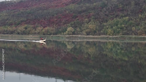 Мotor boat floating on the river at cloudi day photo