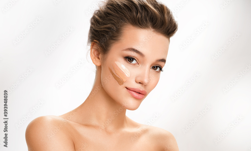 Beautiful woman with tone cream lines on her face. Photo of brunette woman with perfect makeup on white background. Skin care concept Beautiful woman with tone cream lines on her face. Photo of brunette woman with perfect makeup on white background. Skin care concept