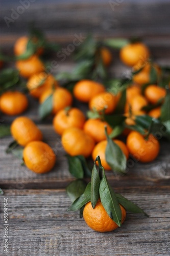 Juicy tangerines with green leaves on a wooden table 