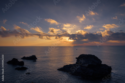 Beautiful cloudy sunrise from a cliff in Cabo de Palos with the sun reflected in the sea water, Murcia, Spain