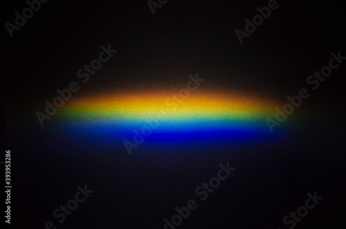 A spot of decomposed light on a dark background. Light spectrum.