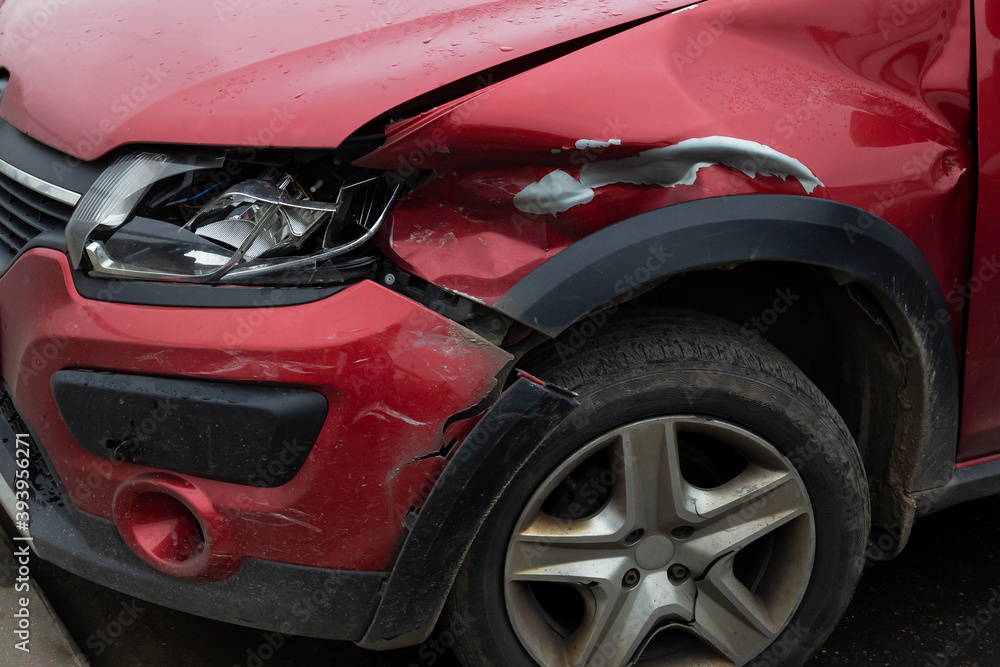 The front part of a red broken car: bumper, hood, light, fender. The car that was in the accident. The front part of a red broken car: bumper, hood, light, fender. The car that was in the accident.