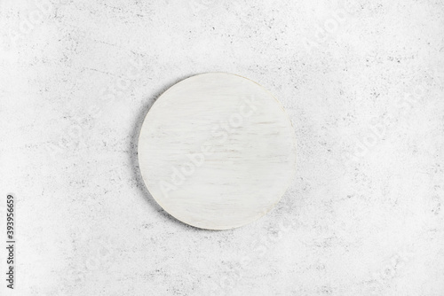 Wooden white cutting board over light stone background