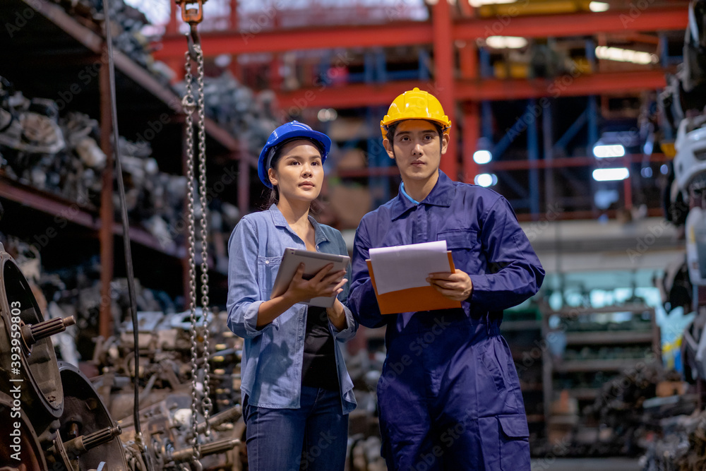 Warehouse woman work with factory worker and also discuss together about quality and stock of automotive parts in workplace area. Concept of good management and support system for industrial business. Warehouse woman work with factory worker and also discuss together about quality and stock of automotive parts in workplace area. Concept of good management and support system for industrial business.