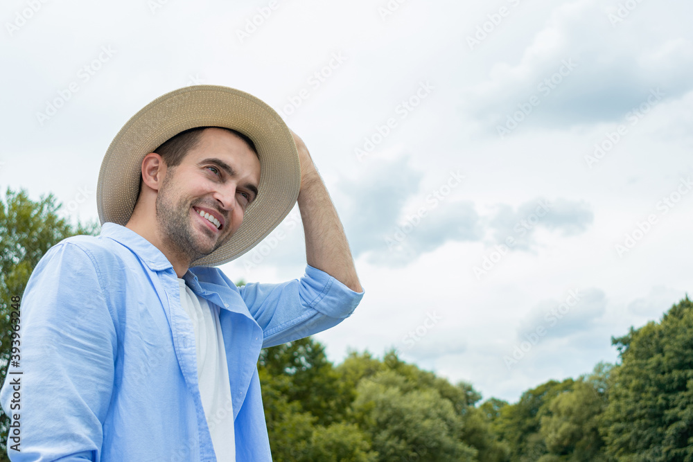 Obraz premium Smiling cowboy adjusts his hat, handsome man smiling at camera, portrait