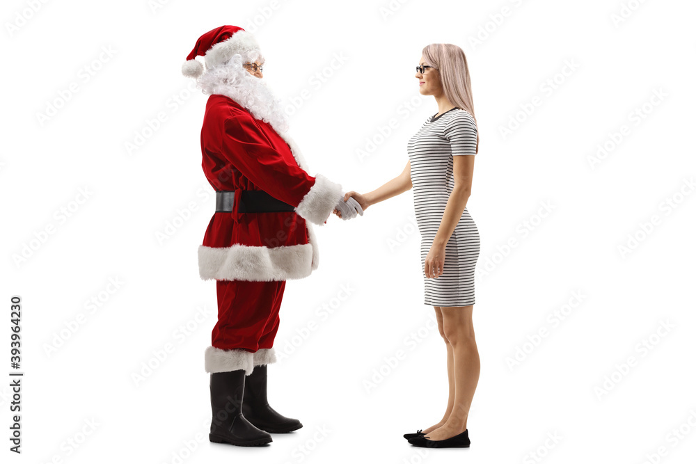 Full length profile shot of a young blond woman shaking hand with santa claus