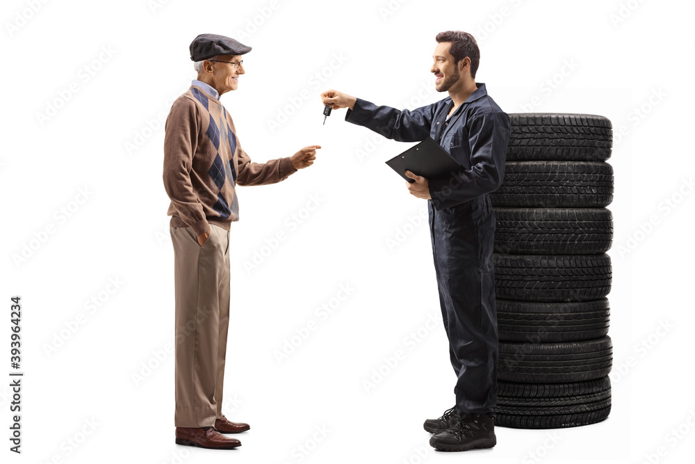 Full length profile shot of an autot mechanic worker returning car keys to an elderly man Full length profile shot of an autot mechanic worker returning car keys to an elderly man