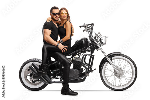 Man and woman in embrace sitting on a chopper motorbike