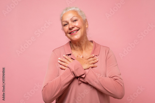 Fotografie Delighted happy charming old lady with white hair smiling at camera