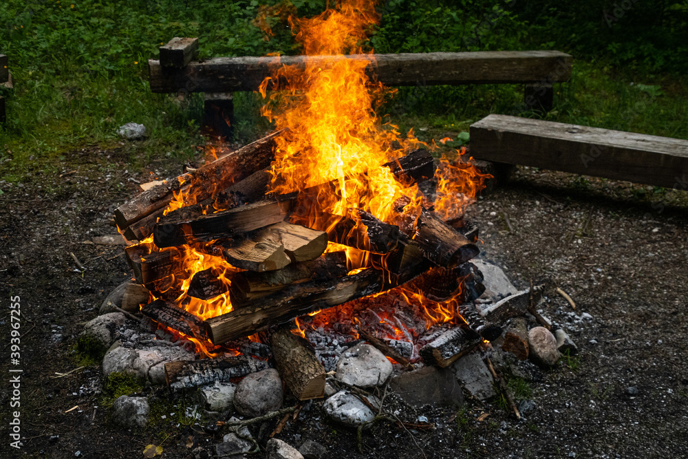 Großes Lagerfeuer mit Holz und Holzstämmen 