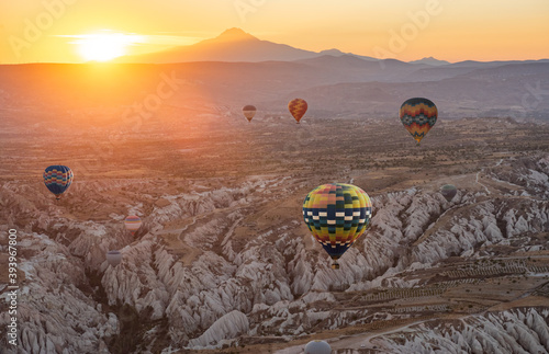 Hot air balloon flying over Cappadocia region, Goreme, Turkey. Great tourist attraction - sunrise balloning over Cappadocia valleys photo