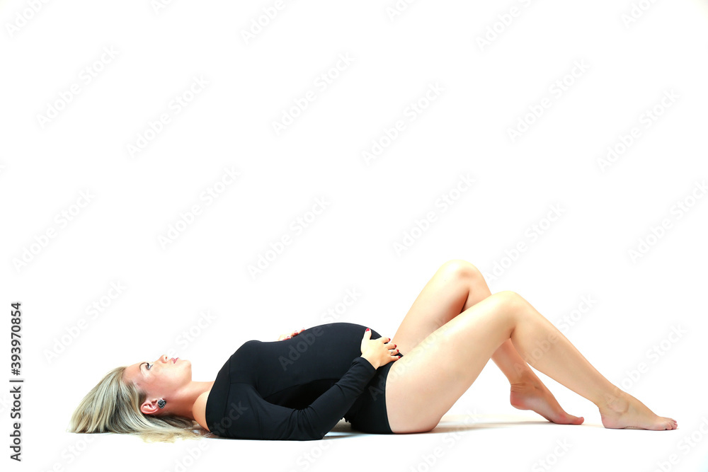 pregnant woman in black bodysuit lying full length on white background pregnant woman in black bodysuit lying full length on white background