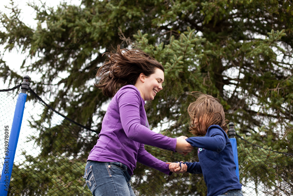 Fototapeta premium Happy Mother and Daughter Jumping on Trampoline Together