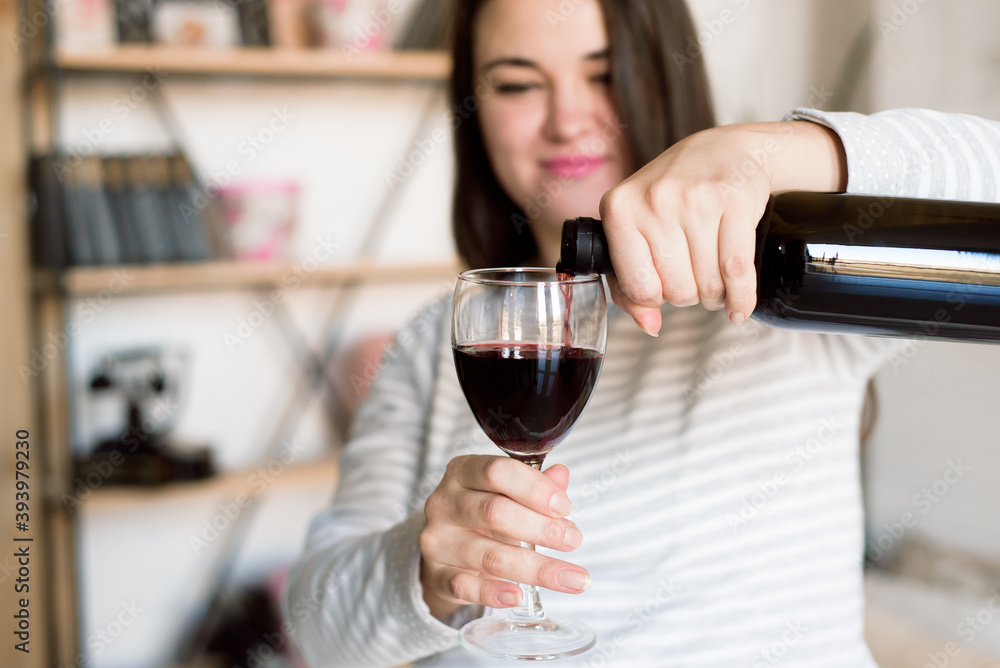 Pregnant alcoholic woman is pouring wine from a bottle into a glass and drinking. Pregnant alcoholic woman is pouring wine from a bottle into a glass and drinking.