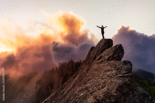 Adventurous Girl on top of a rugged rocky mountain. Dramatic Colorful Sunrise Sky Art Render. Taken on Crown Mountain, North Vancouver, BC, Canada.