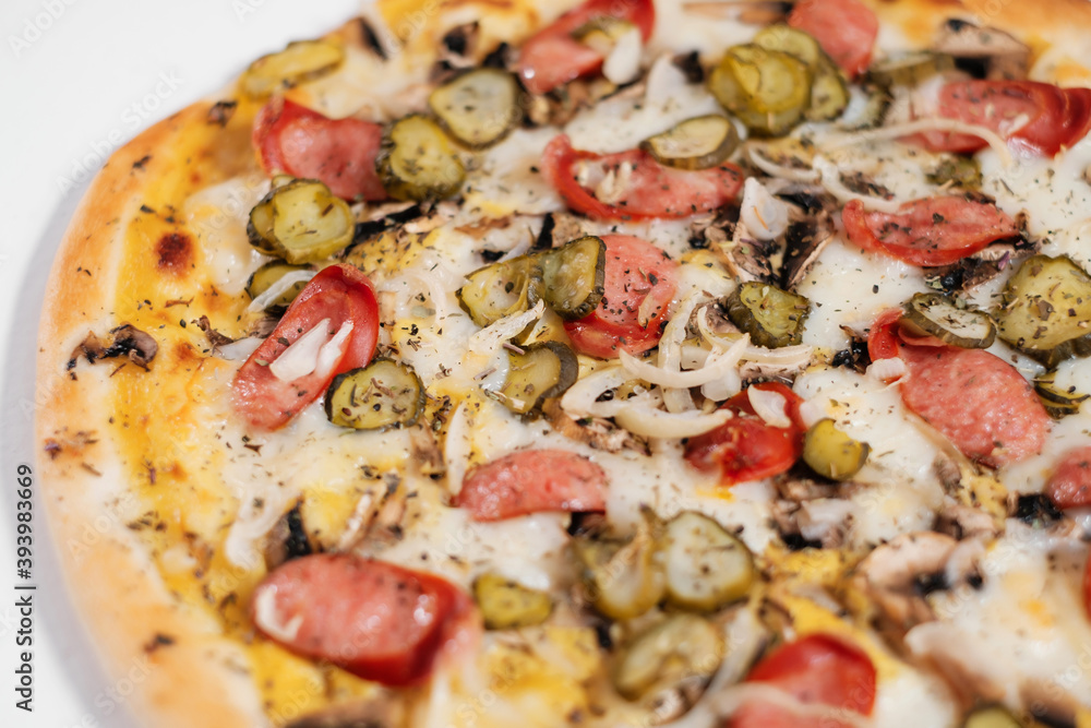 Italian pizza with sausage, mushrooms, onions and pickled cucumbers side view. Italian pizza with sausage, mushrooms, onions and pickled cucumbers side view.