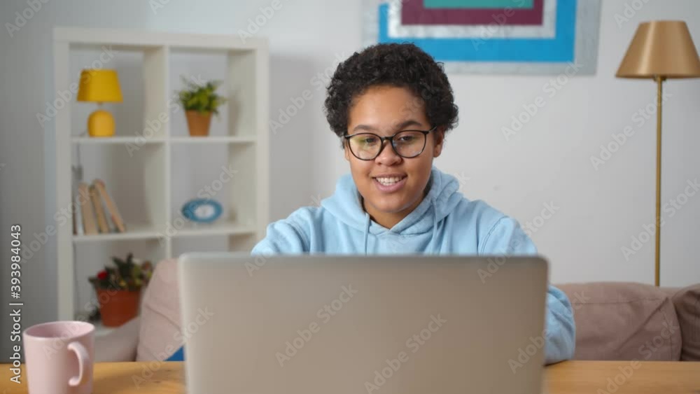Young african woman sitting at home and using app on laptop for video call Young african woman sitting at home and using app on laptop for video call